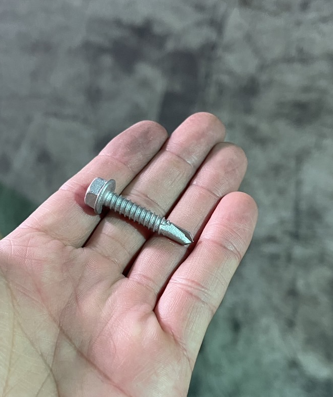 Bi-metal concrete screw anchor with stainless steel body and hardened steel tip, designed for high-strength concrete fastening applications.